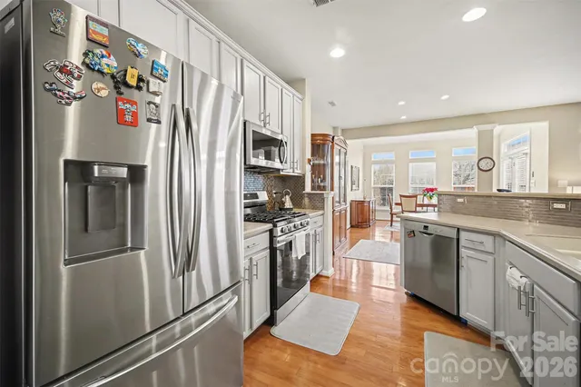 a kitchen with stainless steel appliances granite countertop a refrigerator and a sink