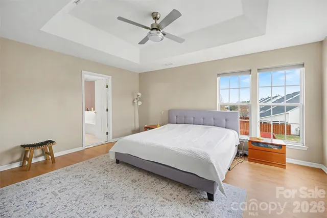 a bedroom with a bed and dresser with wooden floor