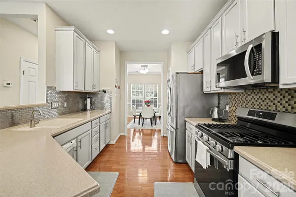 a kitchen with stainless steel appliances a stove a sink and a microwave