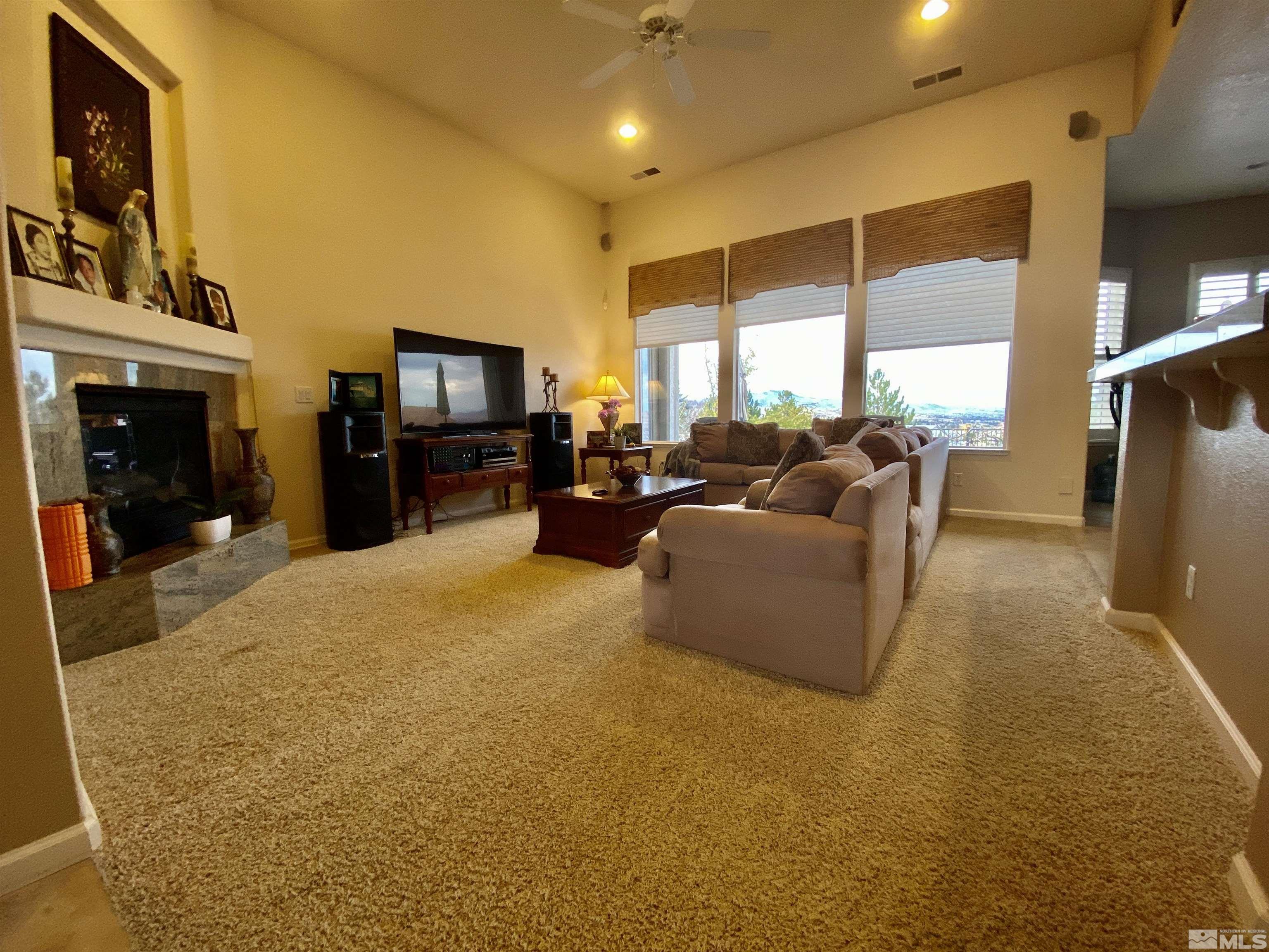755 Sandoval Road Reno, NV 89511 - Photo 12 of 40 a living room with furniture a flat screen tv and a fireplace