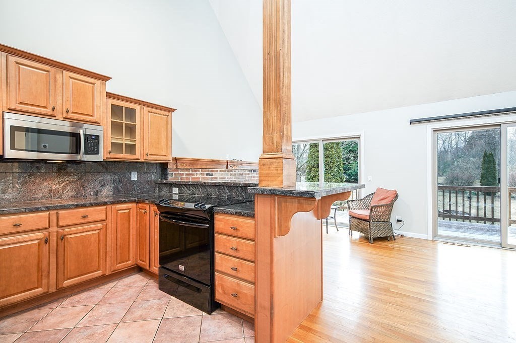 200 Brimfield Road, Unit 200 Monson, MA 01057 - Photo 3 of 13 a kitchen with stainless steel appliances granite countertop a stove a sink and a microwave
