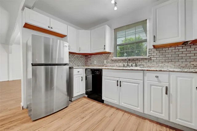 a kitchen with stainless steel appliances granite countertop a refrigerator sink and cabinets