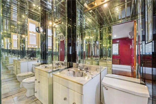 a bathroom with a sink and mirror with toilet