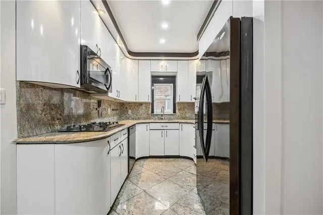 a kitchen with granite countertop a sink and stainless steel appliances