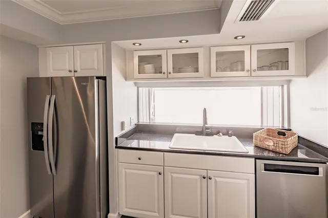 a kitchen with stainless steel appliances granite countertop a refrigerator and a sink