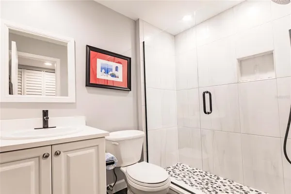 a bathroom with a sink a toilet and shower