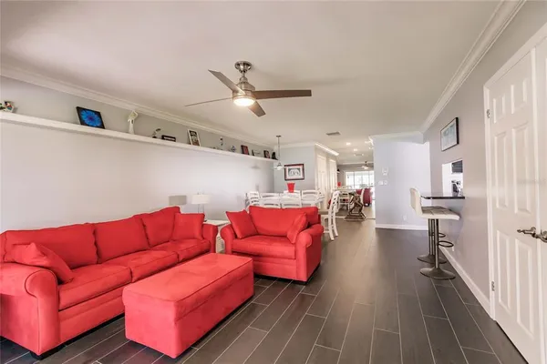 a living room with furniture a ceiling fan and a rug