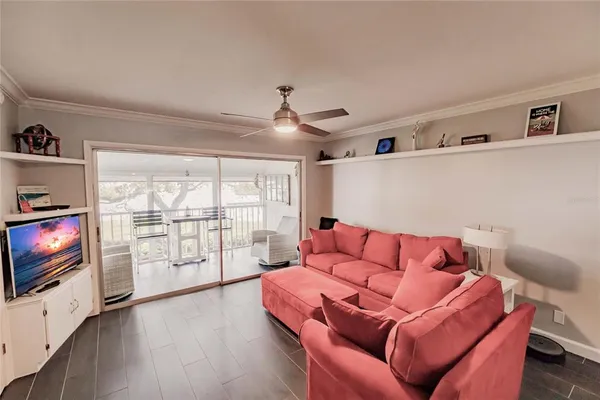 a living room with furniture a flat screen tv and floor to ceiling window
