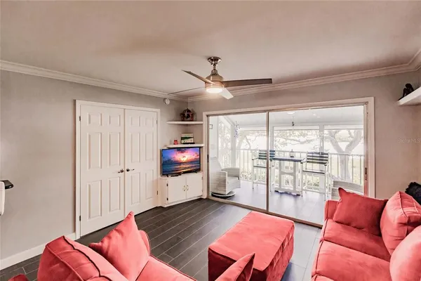 a living room with furniture a flat screen tv and a window
