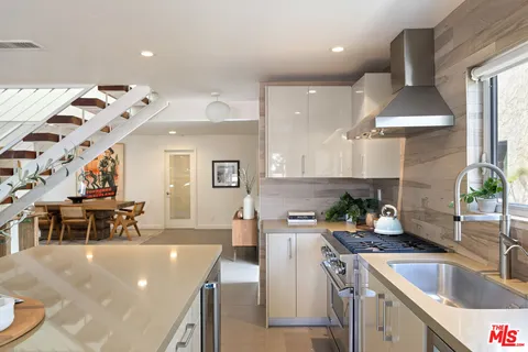 a kitchen that has a lot of cabinets a sink and a stove in it