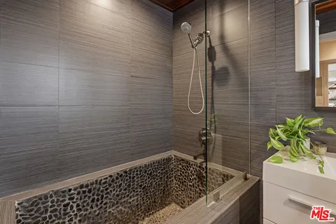 a bathroom with a granite countertop bathtub next to a window