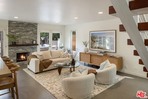 a living room with fireplace furniture and a large window