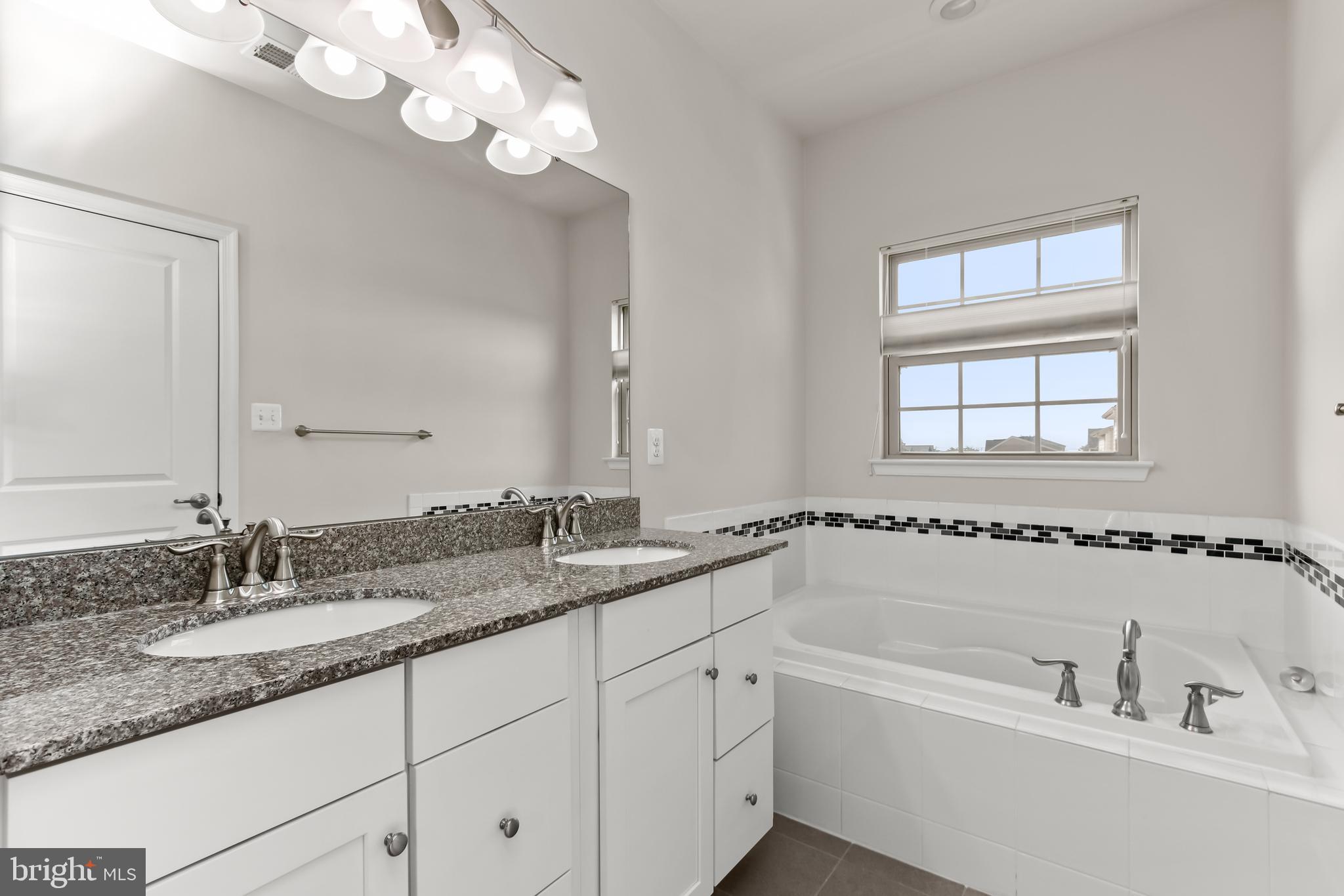 14311 Ridge View Lane Laurel, MD 20707 - Photo 17 of 29 a bathroom with a granite countertop sink a large mirror and a bathtub