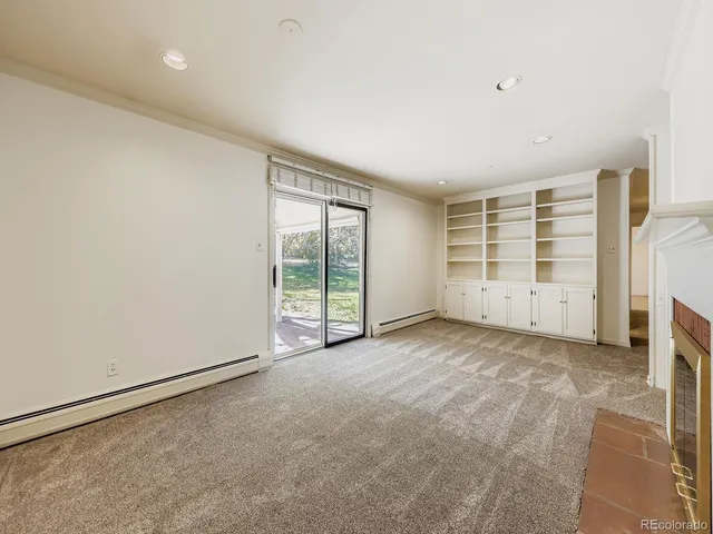 an empty room with a wooden floor and windows