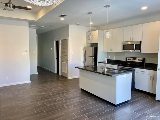 a kitchen with stainless steel appliances a refrigerator a stove a sink and a oven