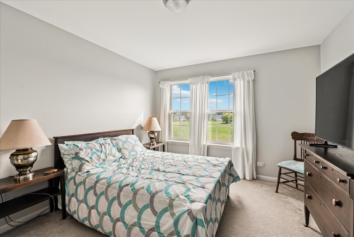 311 Market Street Genoa, IL 60135 - Photo 15 of 24 a bedroom with a bed and a flat tv screen on a dresser