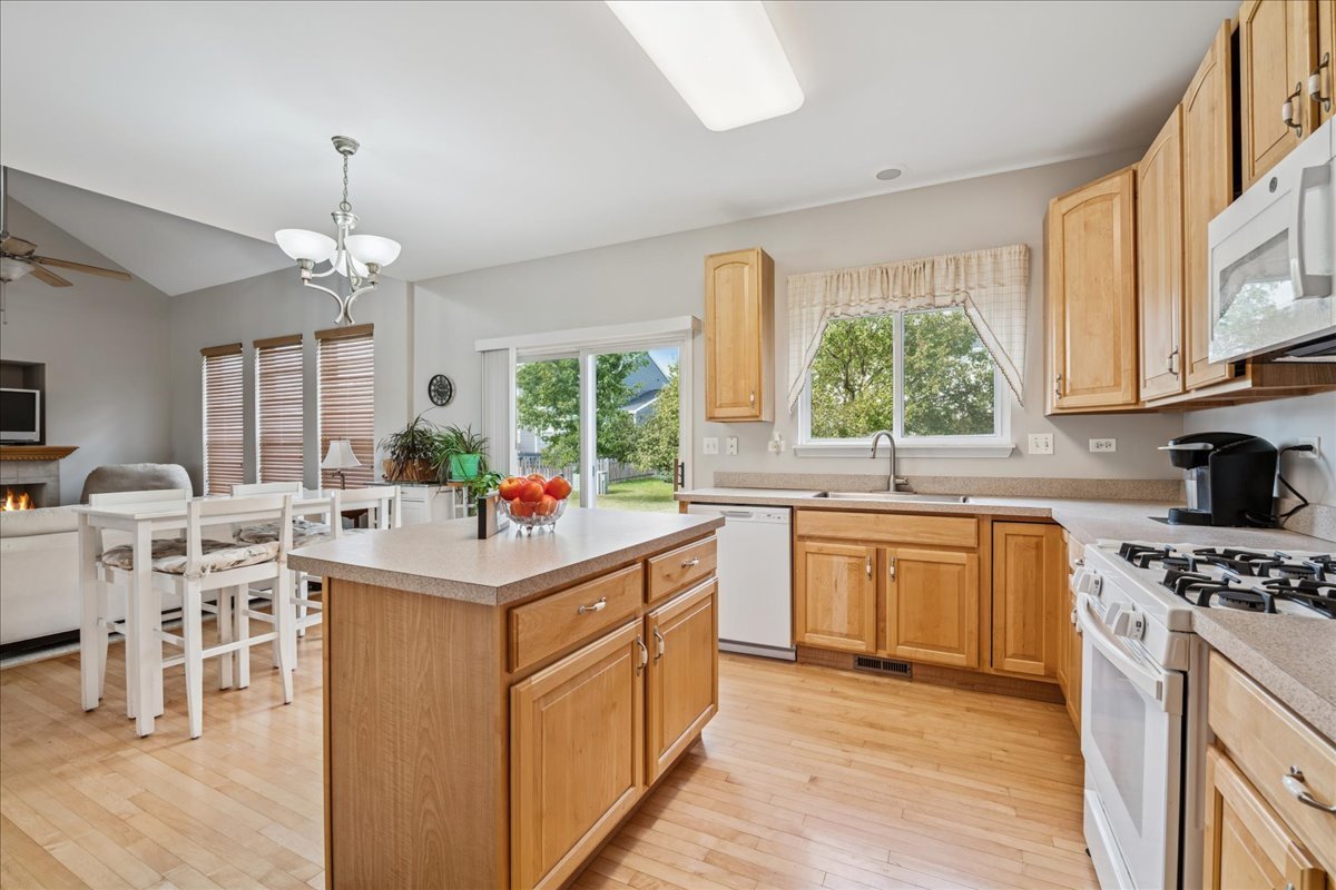 311 Market Street Genoa, IL 60135 - Photo 9 of 24 a kitchen with stainless steel appliances a stove top oven sink a window and white cabinets