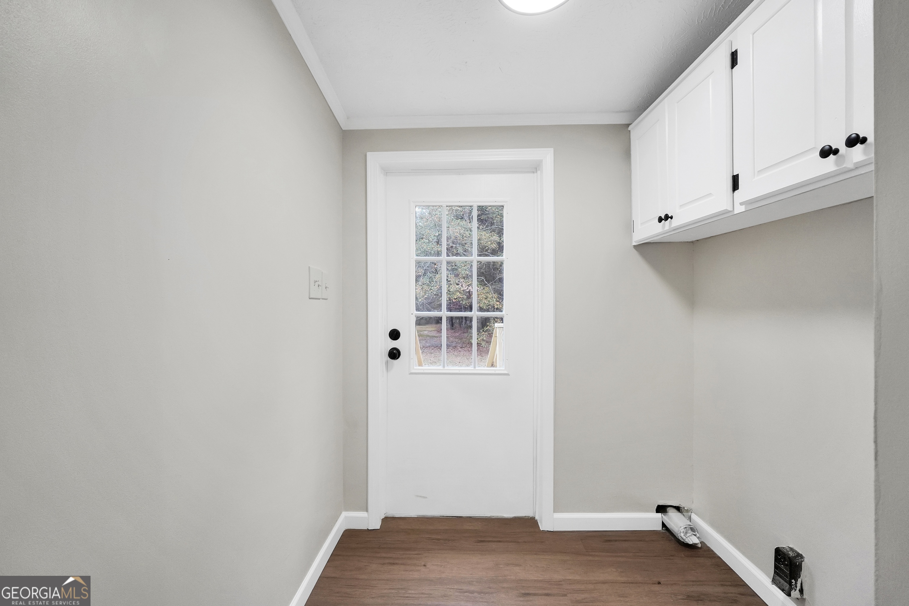196 Craig Road Forsyth, GA 31029 - Photo 15 of 39 a view of an empty room with wooden floor and cabinets