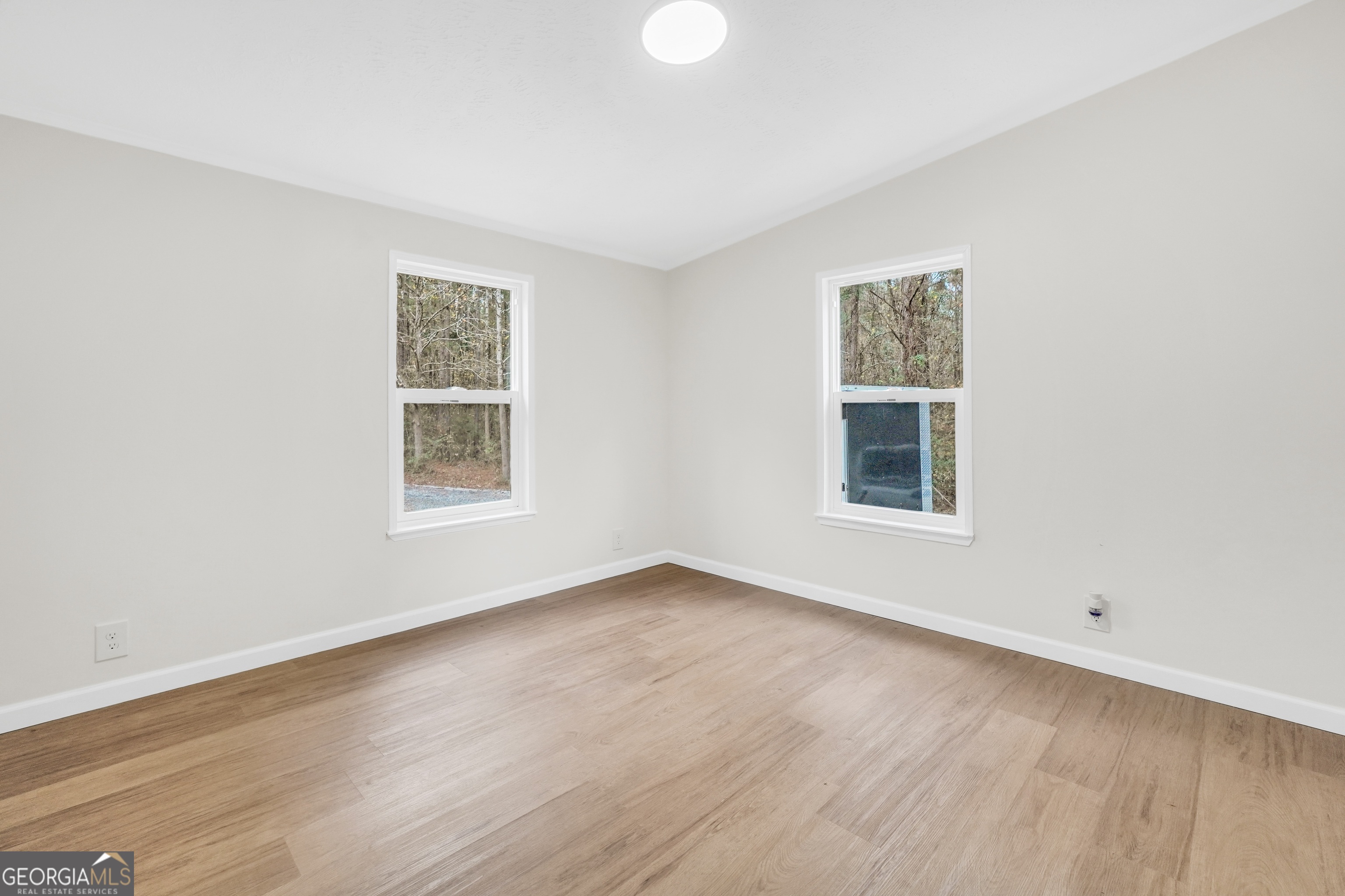 196 Craig Road Forsyth, GA 31029 - Photo 21 of 39 an empty room with wooden floor and windows