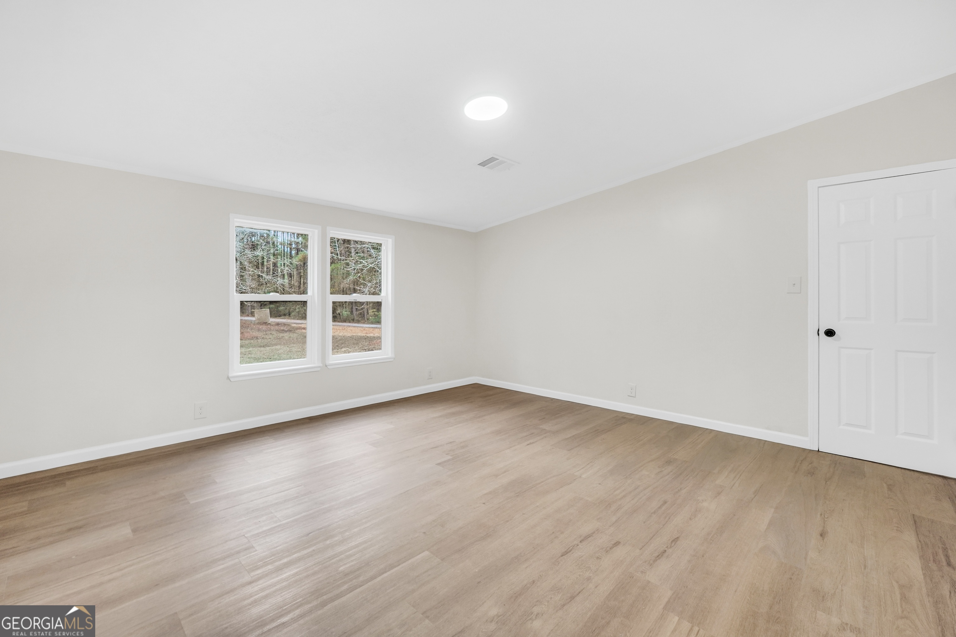 196 Craig Road Forsyth, GA 31029 - Photo 28 of 39 an empty room with wooden floor and windows