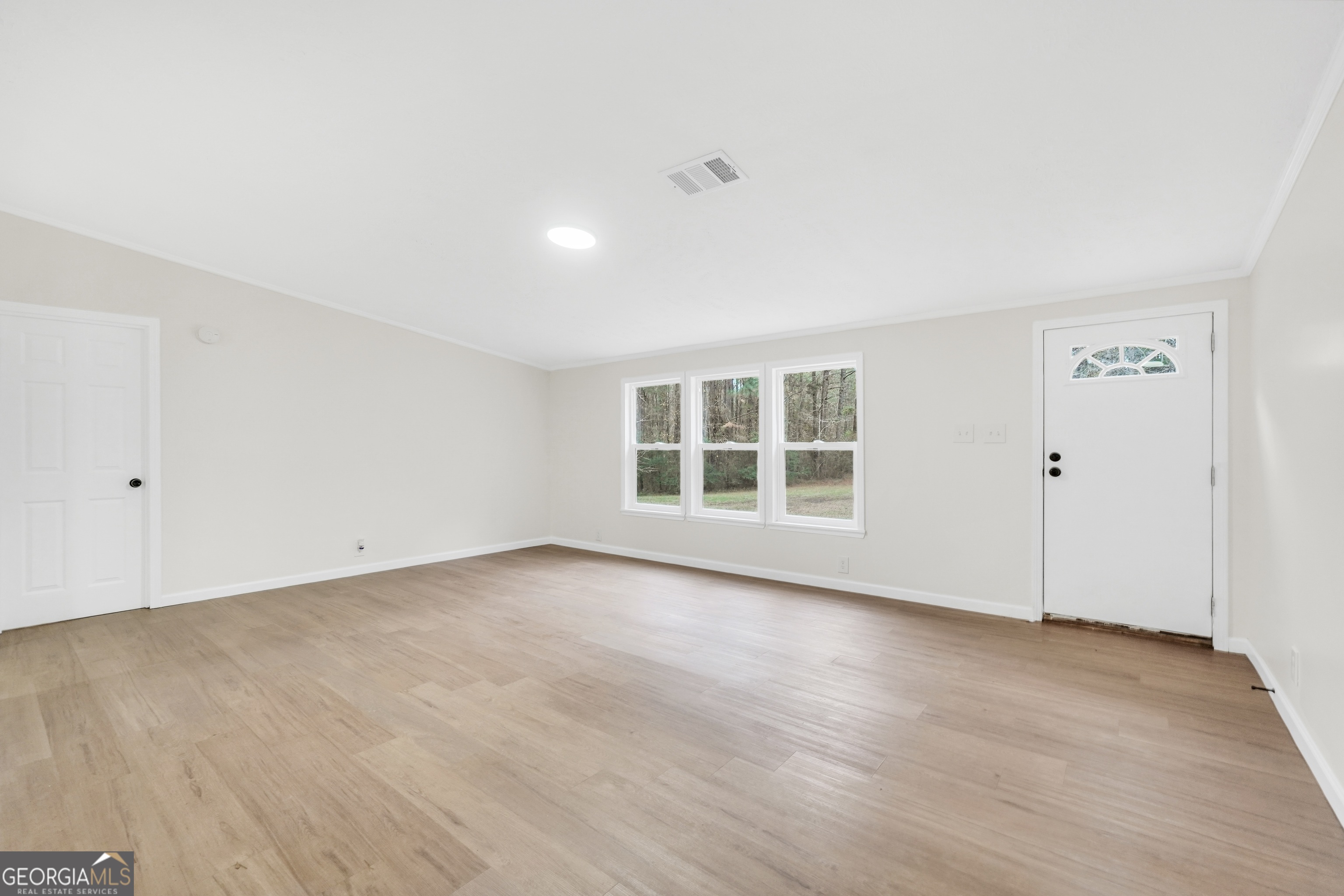 196 Craig Road Forsyth, GA 31029 - Photo 5 of 39 an empty room with wooden floor and windows