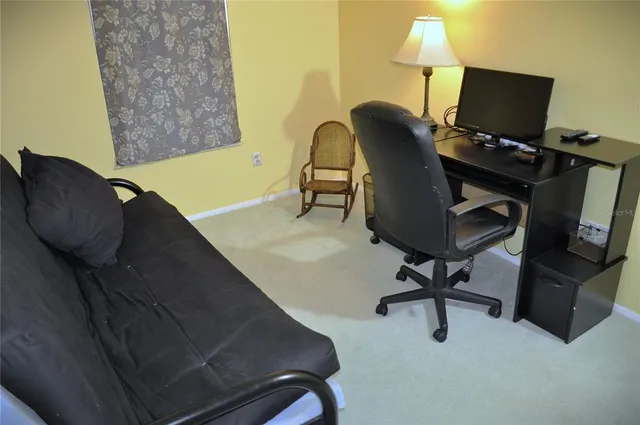 a view of a workspace with furniture and a window
