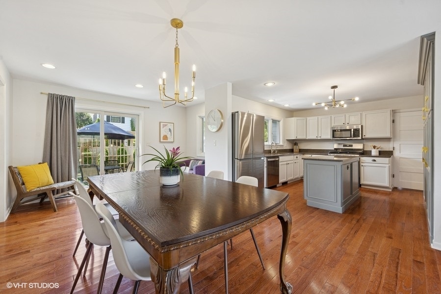 527 Maple Lane Geneva, IL 60134 - Photo 16 of 42 a kitchen with stainless steel appliances granite countertop a stove refrigerator a dining table and chairs with wooden floor