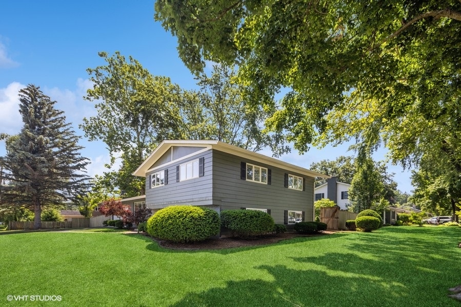 527 Maple Lane Geneva, IL 60134 - Photo 2 of 42 a view of a brick house next to a yard with big trees