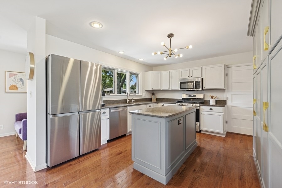 527 Maple Lane Geneva, IL 60134 - Photo 22 of 42 a kitchen with a refrigerator a sink cabinets and wooden floor