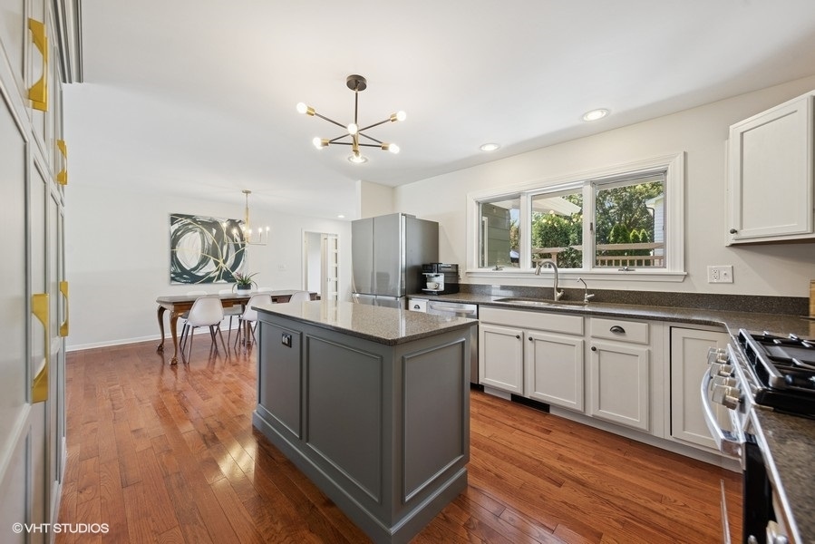 527 Maple Lane Geneva, IL 60134 - Photo 24 of 42 a kitchen with stainless steel appliances granite countertop hardwood floor sink stove dining table and chairs