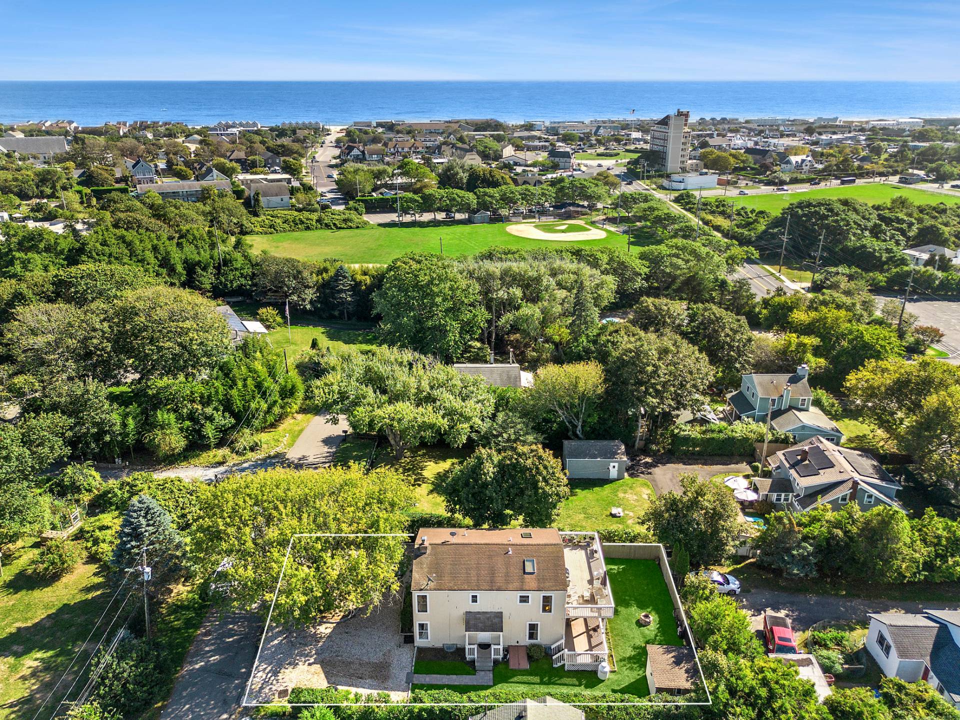 an aerial view of a city with lots of residential buildings ocean and mountain view in back