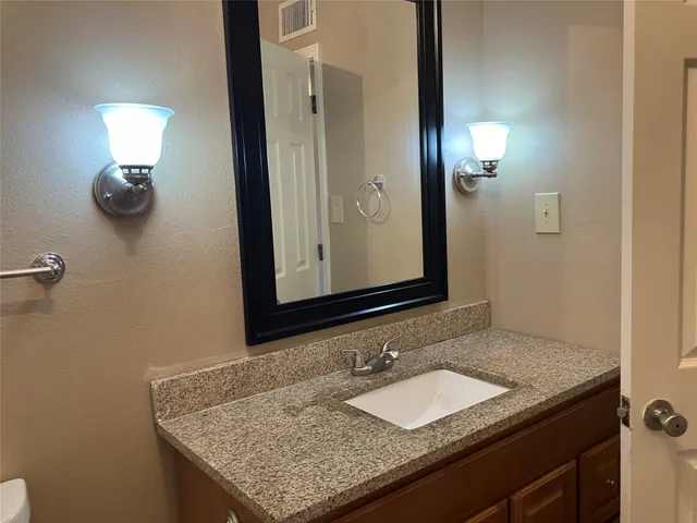 a bathroom with a granite countertop sink and a mirror
