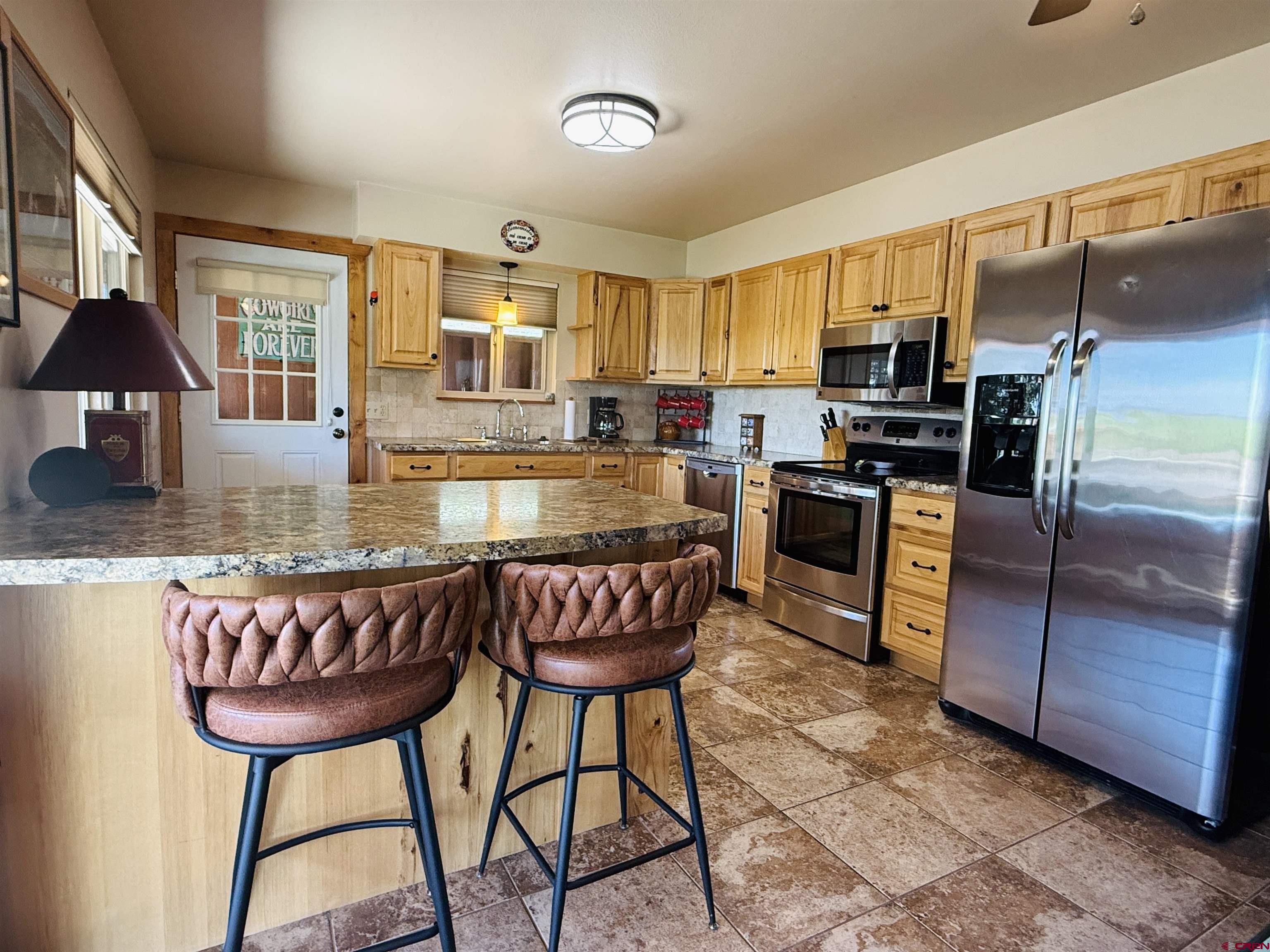 22680 E Road Delta, CO 81416 - Photo 19 of 31 a kitchen with a chandelier furniture and a refrigerator