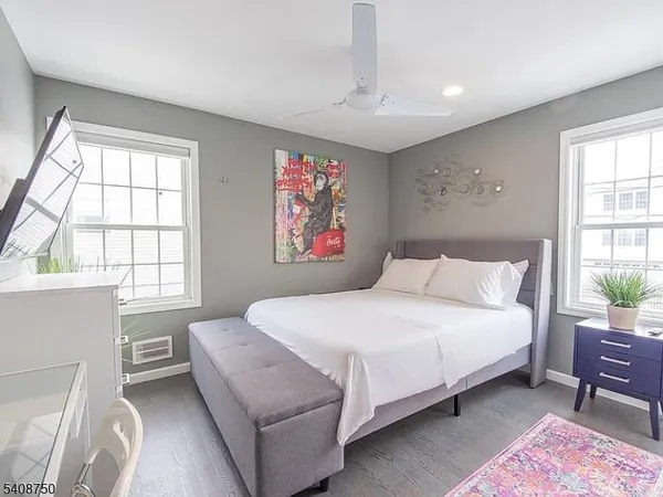 a bedroom with a bed wooden floor and window