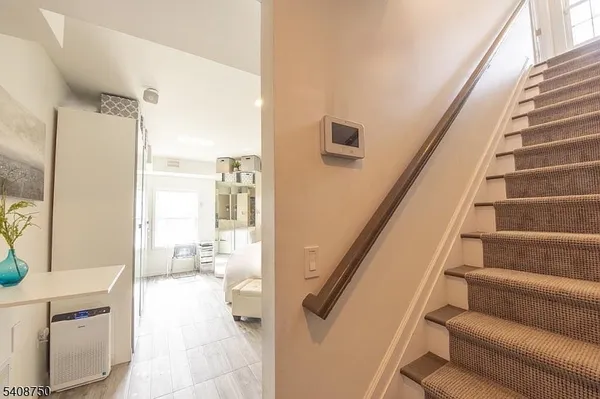 a view of a hallway with furniture and staircase