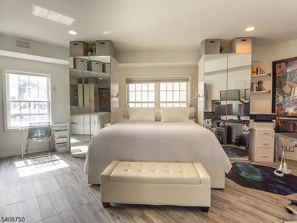a spacious bedroom with a bed a table and large windows