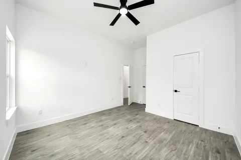 a view of a room with wooden floor and white walls