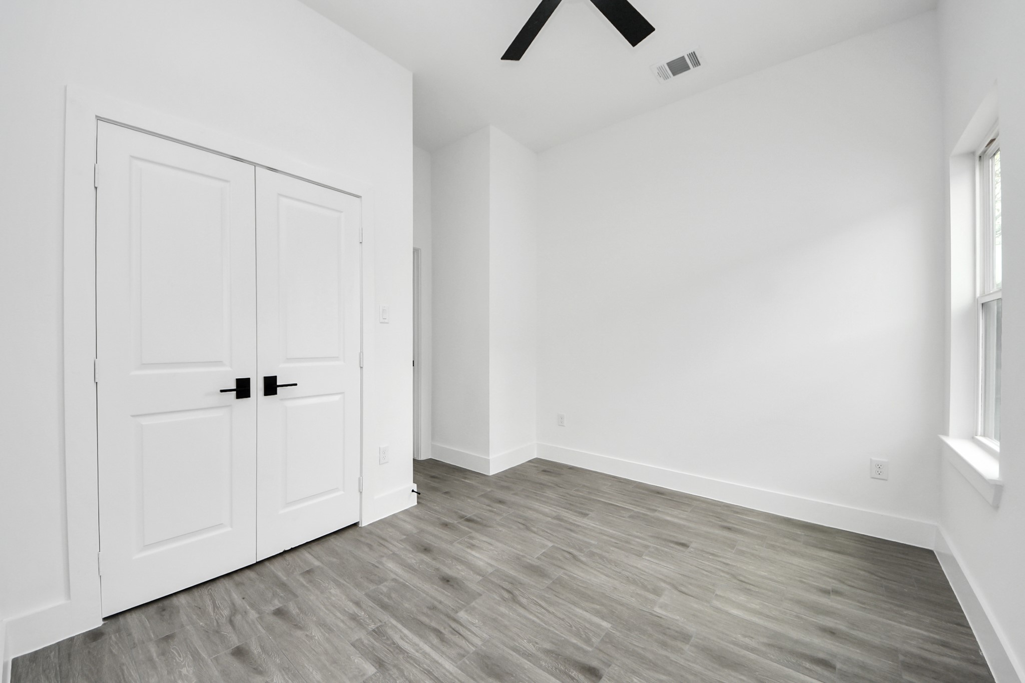 7412 Carver Road, Unit B Houston, TX 77088 - Photo 17 of 22 an empty room with wooden floor and windows