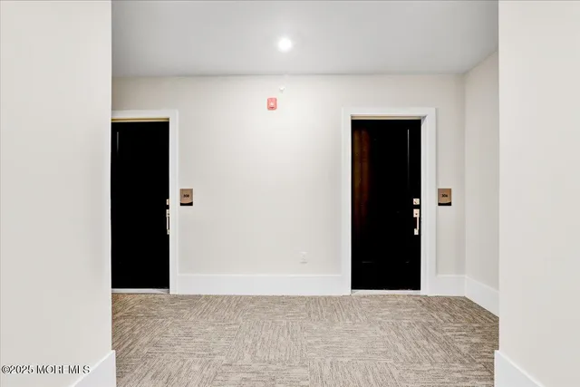 a view of a hallway with wooden floor and a carpet