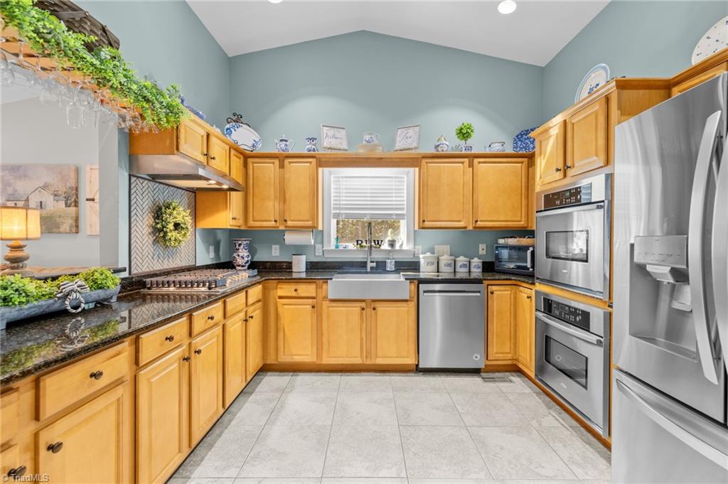 3930 Cole Avenue High Point, NC 27265 - Photo 9 of 44 Chef's kitchen, tiled, vaulted ceiling with beautiful cabinetry, granite, custom tiled backsplash, gas cooktop, built in oven and microwace