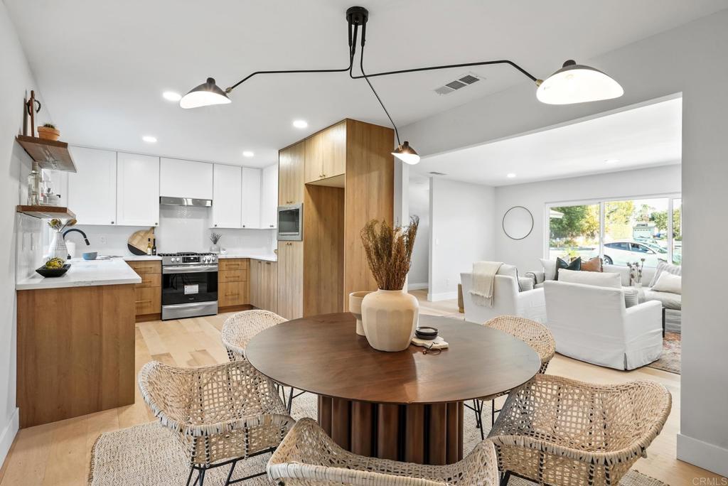 5898 Agee Street San Diego, CA 92122 - Photo 14 of 40 a kitchen with stainless steel appliances granite countertop a stove a kitchen island a dining table and chairs