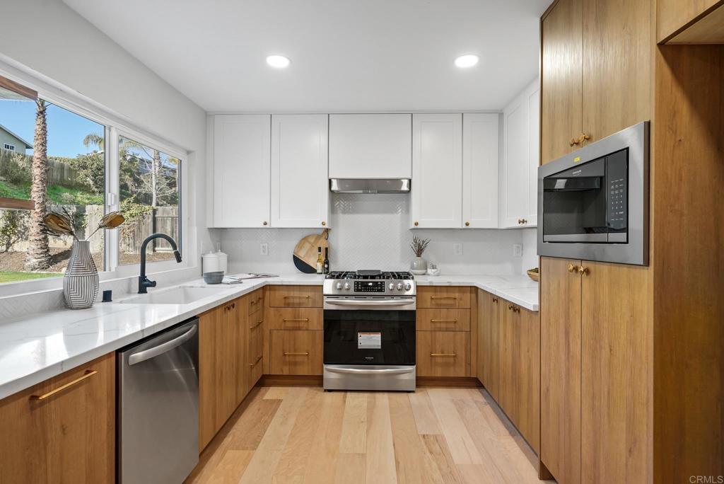 5898 Agee Street San Diego, CA 92122 - Photo 15 of 40 a kitchen with stainless steel appliances granite countertop a stove a sink and a microwave