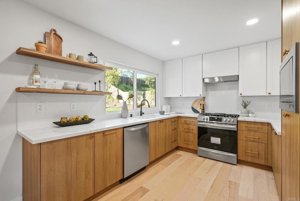 5898 Agee Street San Diego, CA 92122 - Photo 16 of 40 a kitchen with stainless steel appliances granite countertop a sink stove and cabinets