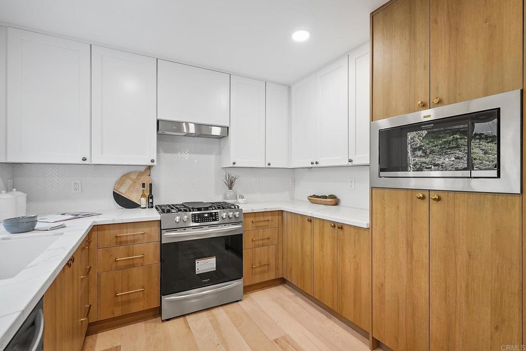 5898 Agee Street San Diego, CA 92122 - Photo 17 of 40 a kitchen with stainless steel appliances granite countertop a stove and a refrigerator