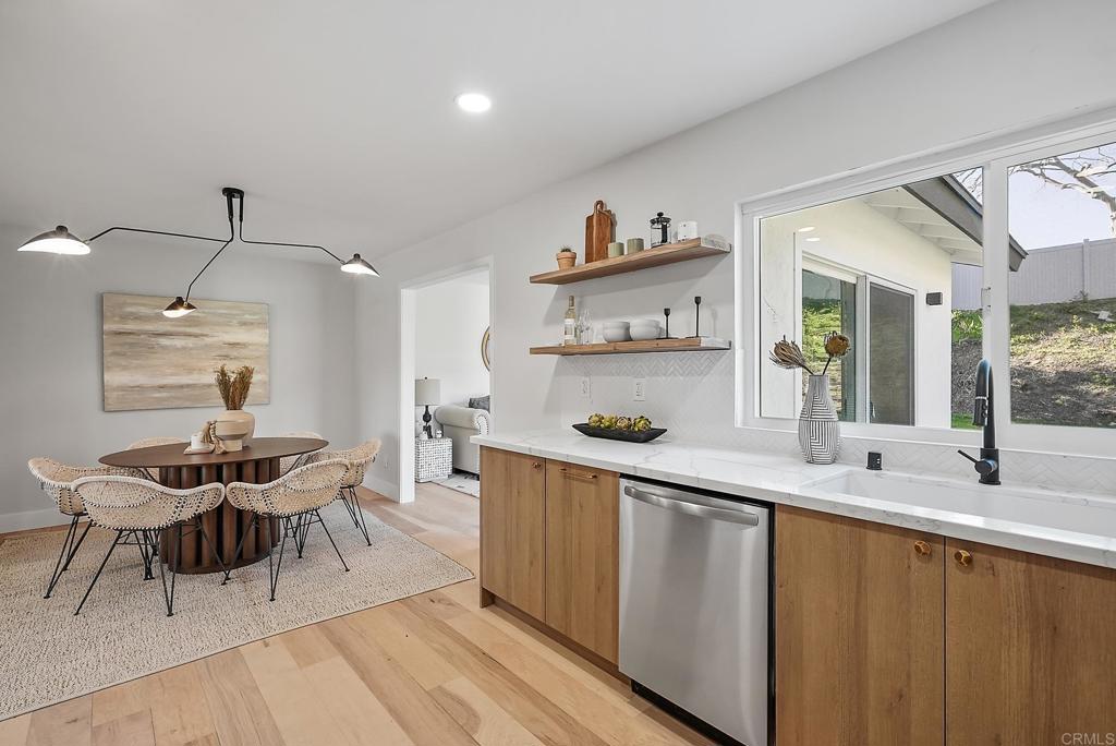 5898 Agee Street San Diego, CA 92122 - Photo 18 of 40 a kitchen with stainless steel appliances a table and chairs in it