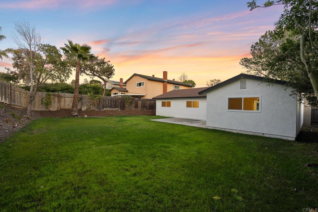 5898 Agee Street San Diego, CA 92122 - Photo 25 of 40 a backyard of a white house with potted plants and large tree