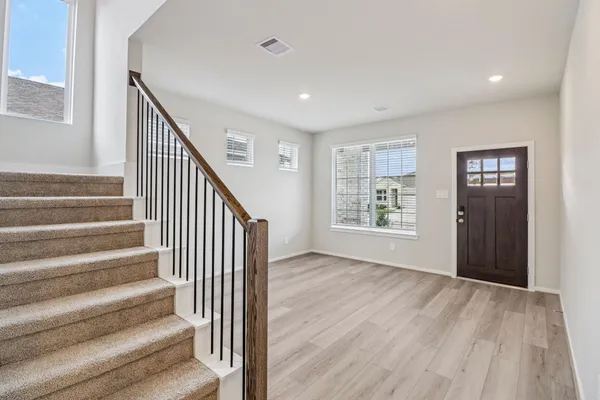 a view of an entryway with wooden floor and stairs