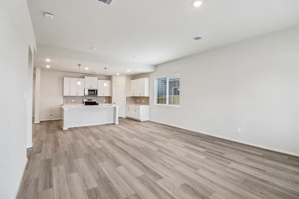 a view of a kitchen with wooden floor and windows