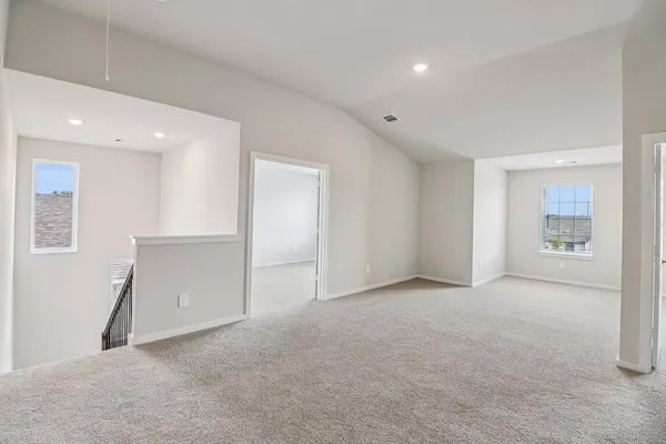 a view of an empty room with closet and a window