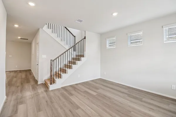 a view of a hallway with wooden floor and entryway
